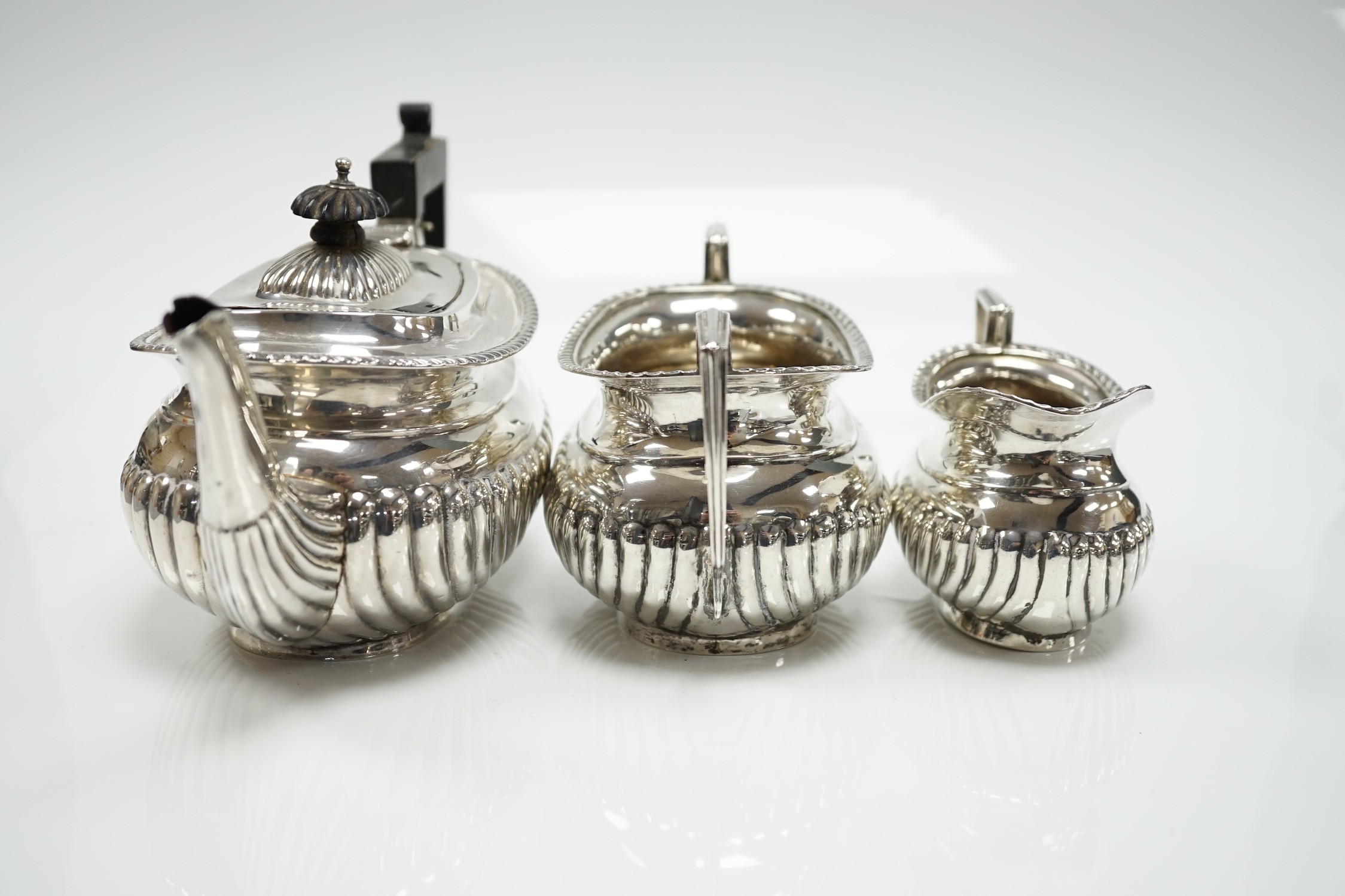 A George V demi fluted silver three piece bachelor's tea set, Jones & Crompton, Birmingham, 1913, gross weight 14.5oz.